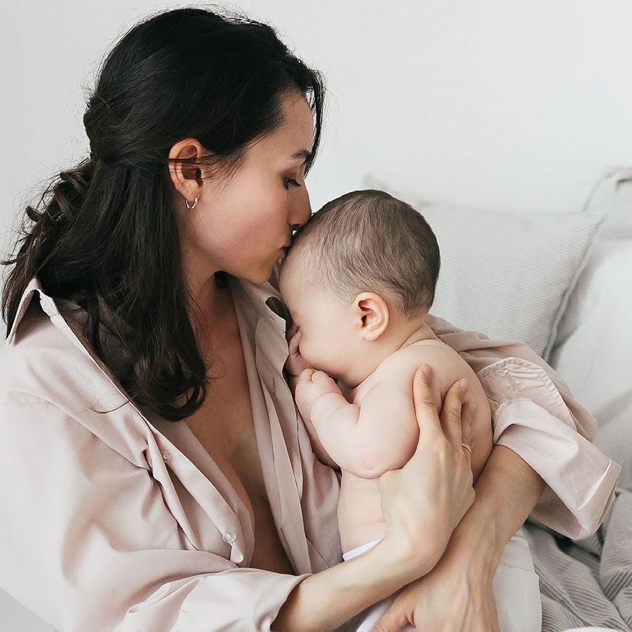 A mother hugging and kissing her baby