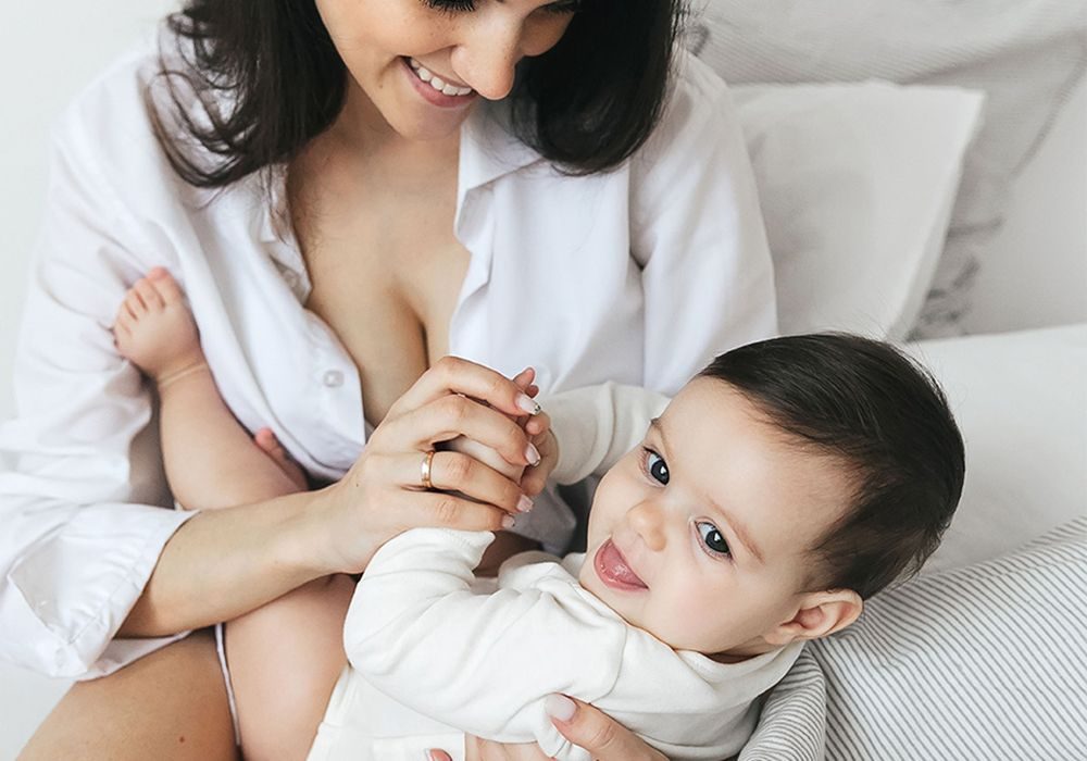 A mother playing with her smiling baby
