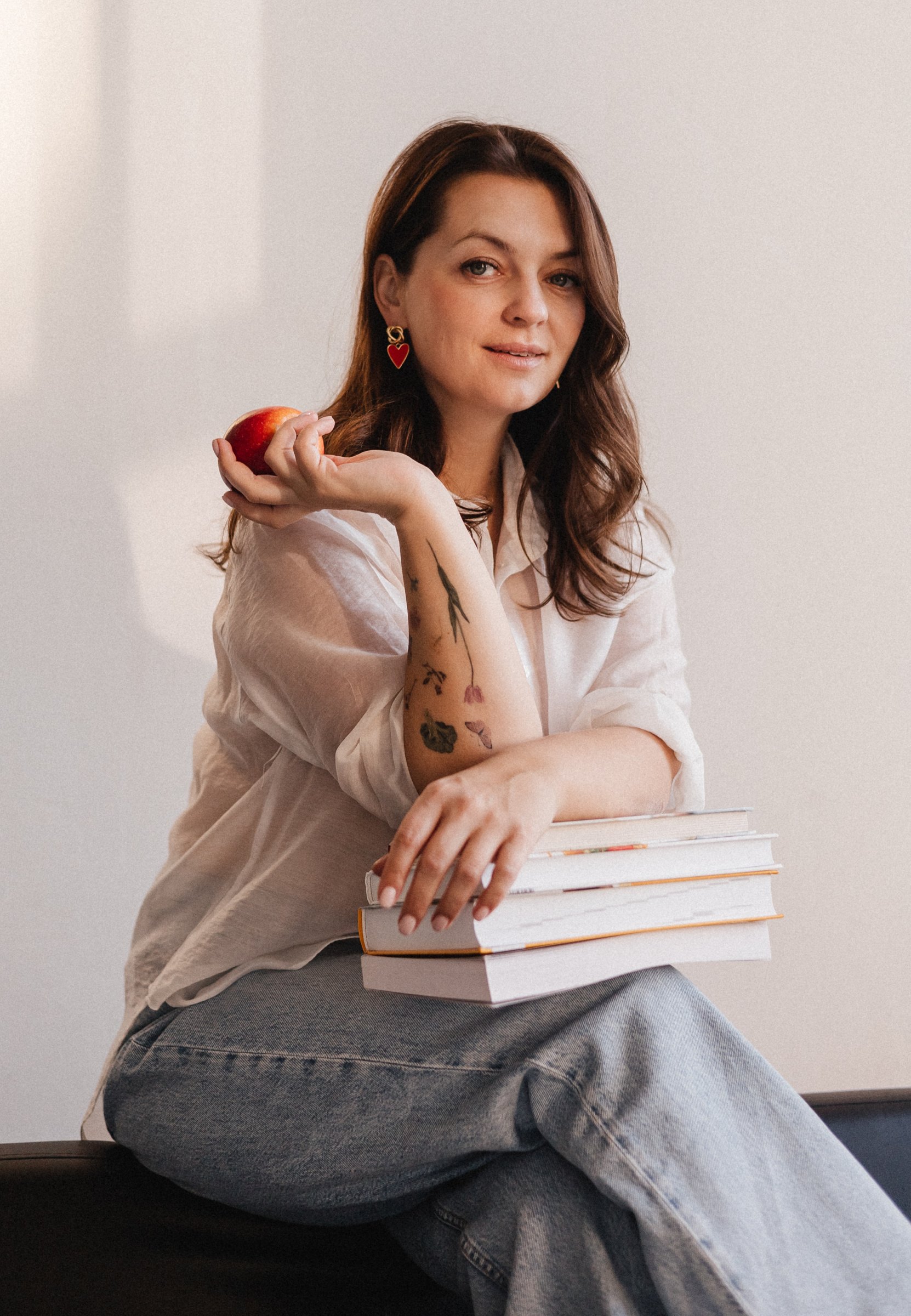 Yulia Klimanova holding an apple and a stack of books