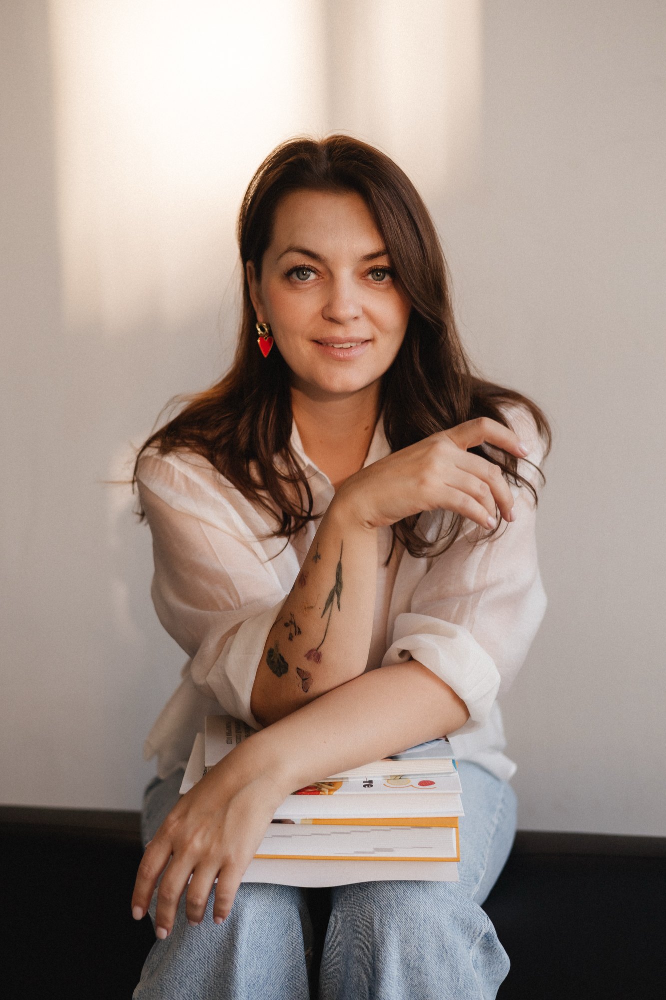 Yulia Klimanova sitting with a stack of books on her lap